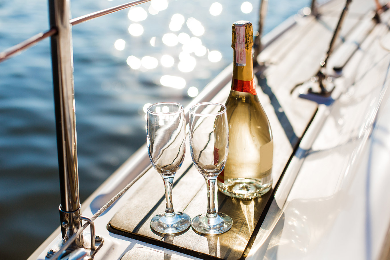 champagne flutes and bottle on deck of luxury yacht